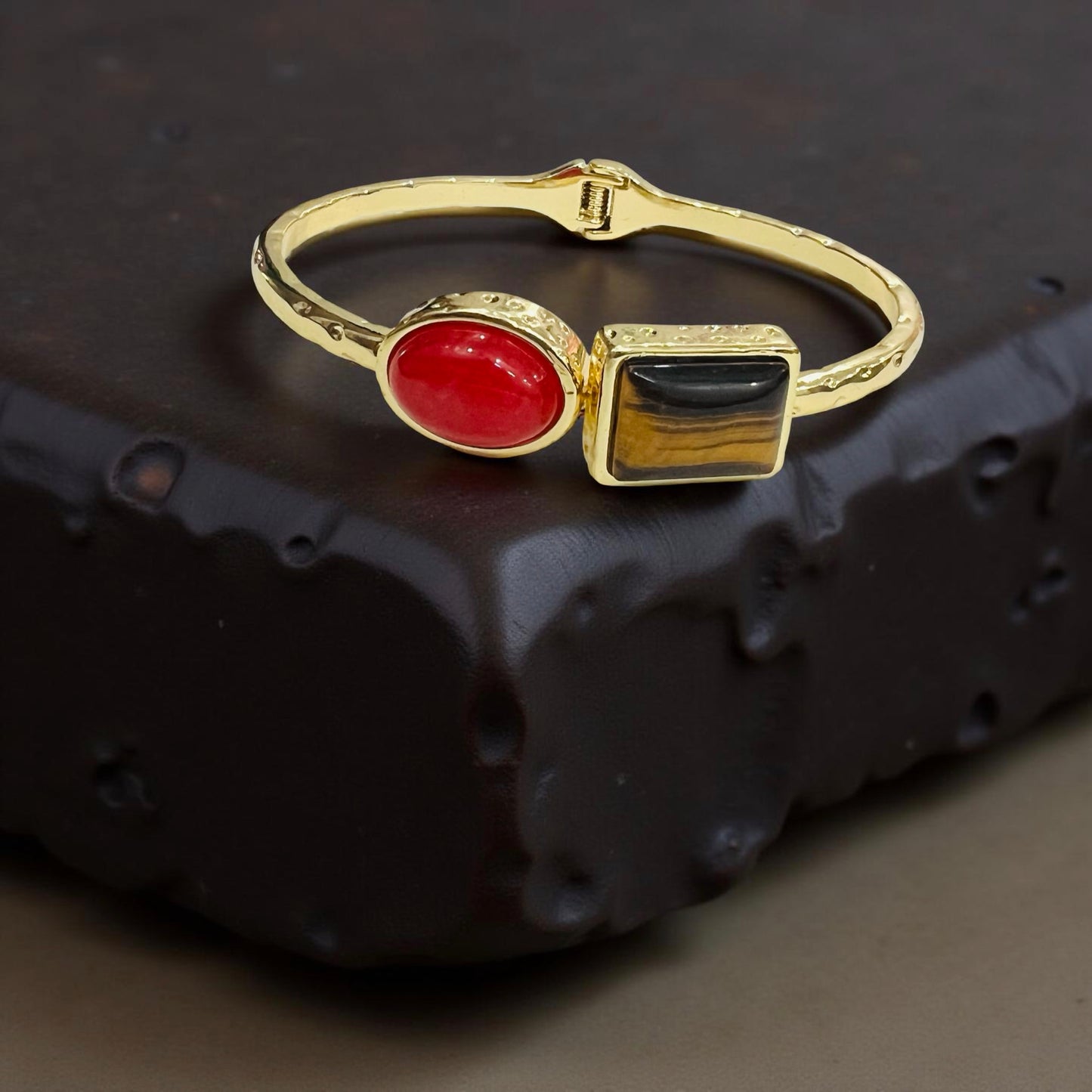 Gold bracelet with dual-stone statement design by Jinam, featuring elegant, eye-catching stones on a sleek bracelet.