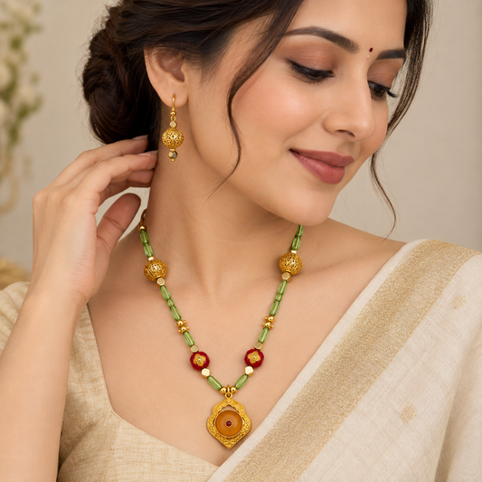 Model wearing Gold Filigree Ball Necklace Set and earrings with cream silk saree
