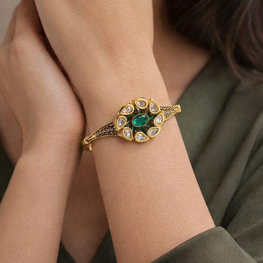 Antique gold-plated Kundan and emerald-style statement bracelet with intricate design and traditional jewelry craftsmanship.