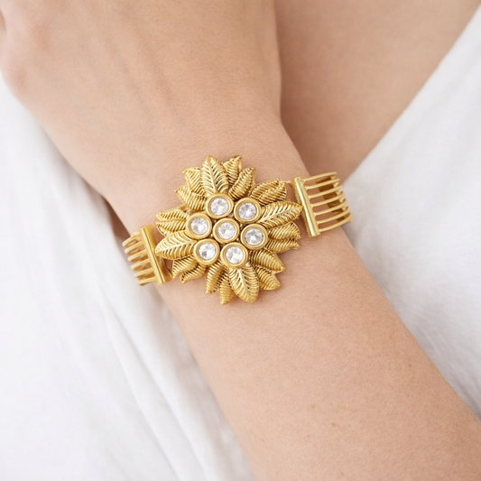 Jinam floral Kundan statement bracelet in antique gold finish with intricate floral and kundan gemstone detailing.