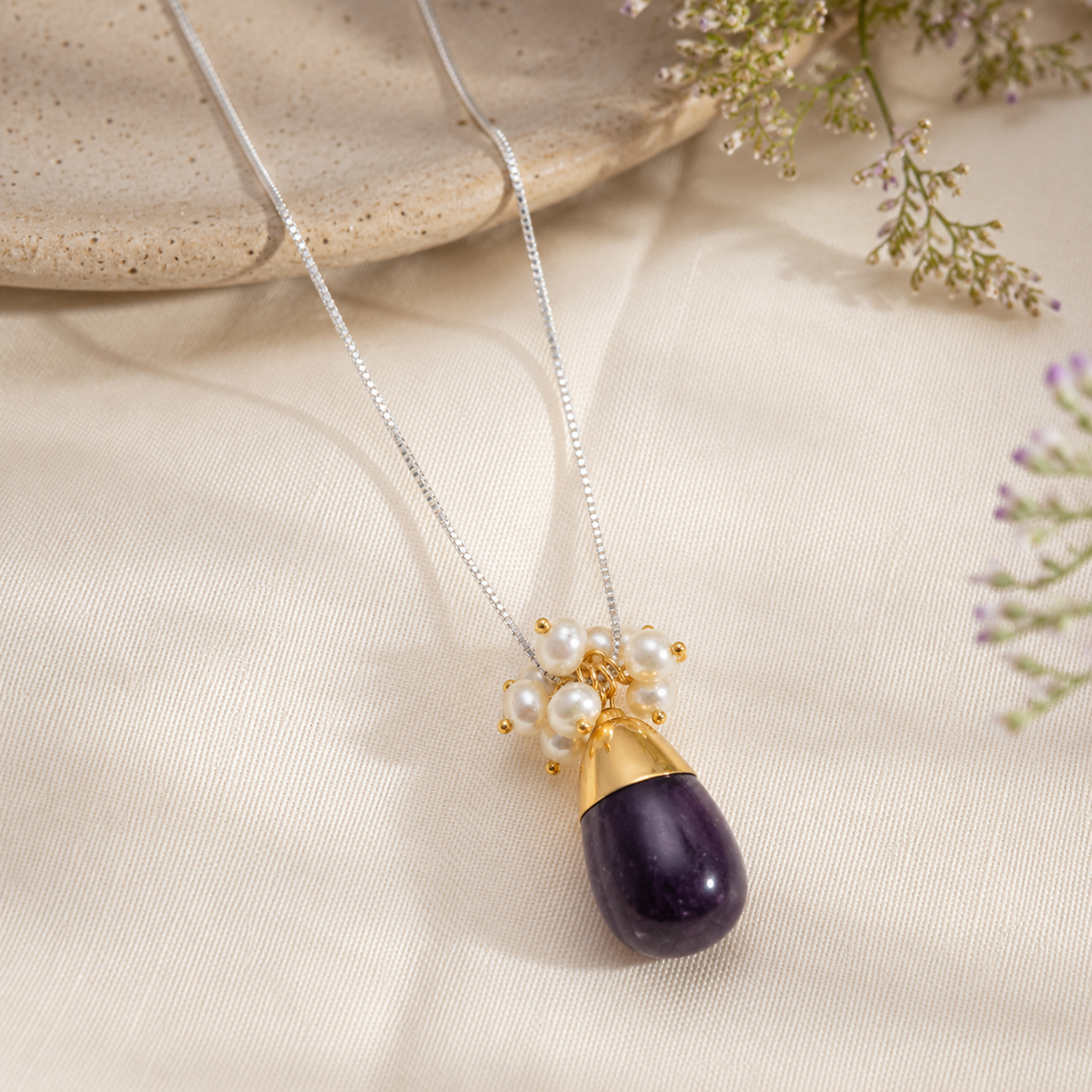 Amethyst Drop and Pearl Cluster Pendant Necklace on cream fabric with flowers