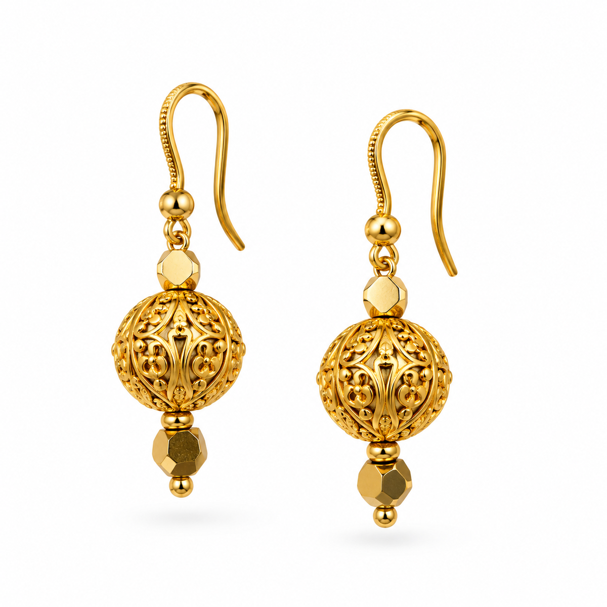 Close up of gold filigree ball drop earrings with hexagonal faceted gold crystal drop on white background