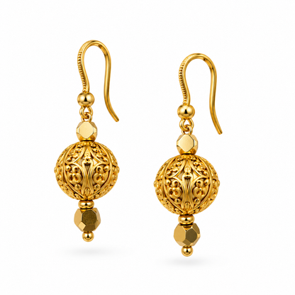 Close up of gold filigree ball drop earrings with hexagonal faceted gold crystal drop on white background