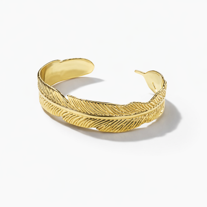 Gold feather bracelet and ring set by Jinam featuring elegant nature-inspired jewelry with delicate feather designs.