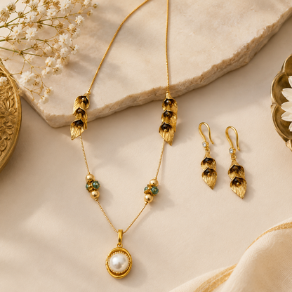 Gold Calla Lily Necklace Set styled on cream stone with dry flowers and earrings