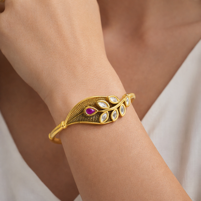 Gold-plated leaf motif Kundan bracelet featuring intricate designs, elegant jewelry piece by Jinam.