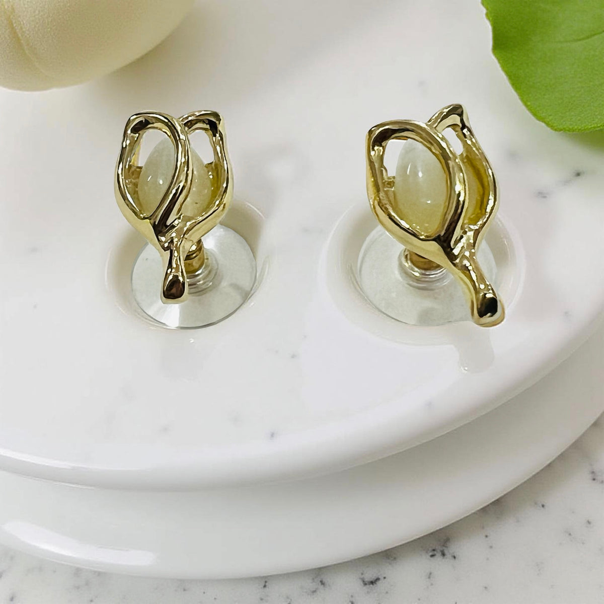 Gold-plated floral bud pendant and earrings set by Jinam, featuring delicate flower designs on matching jewelry pieces.