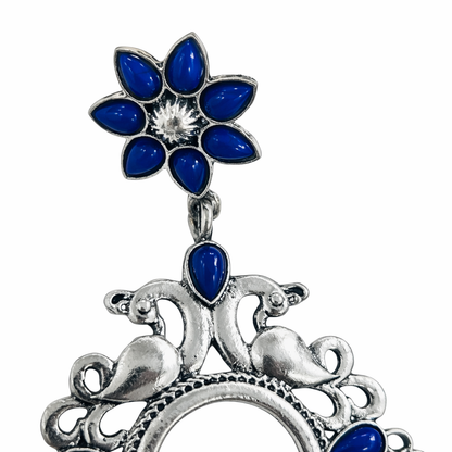 Oxidised silver earrings with blue floral and bird motif by Jinam, showcasing intricate design and detailed craftsmanship.