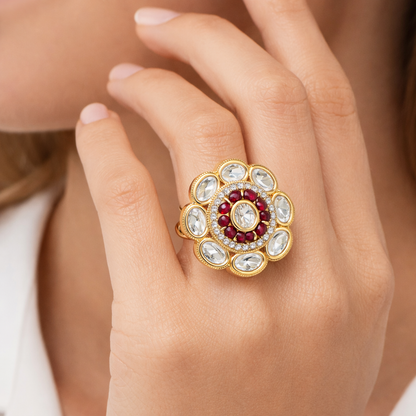 Jinam Ruby Polki floral ring in antique gold finish showcasing intricate floral design and vibrant ruby accents.