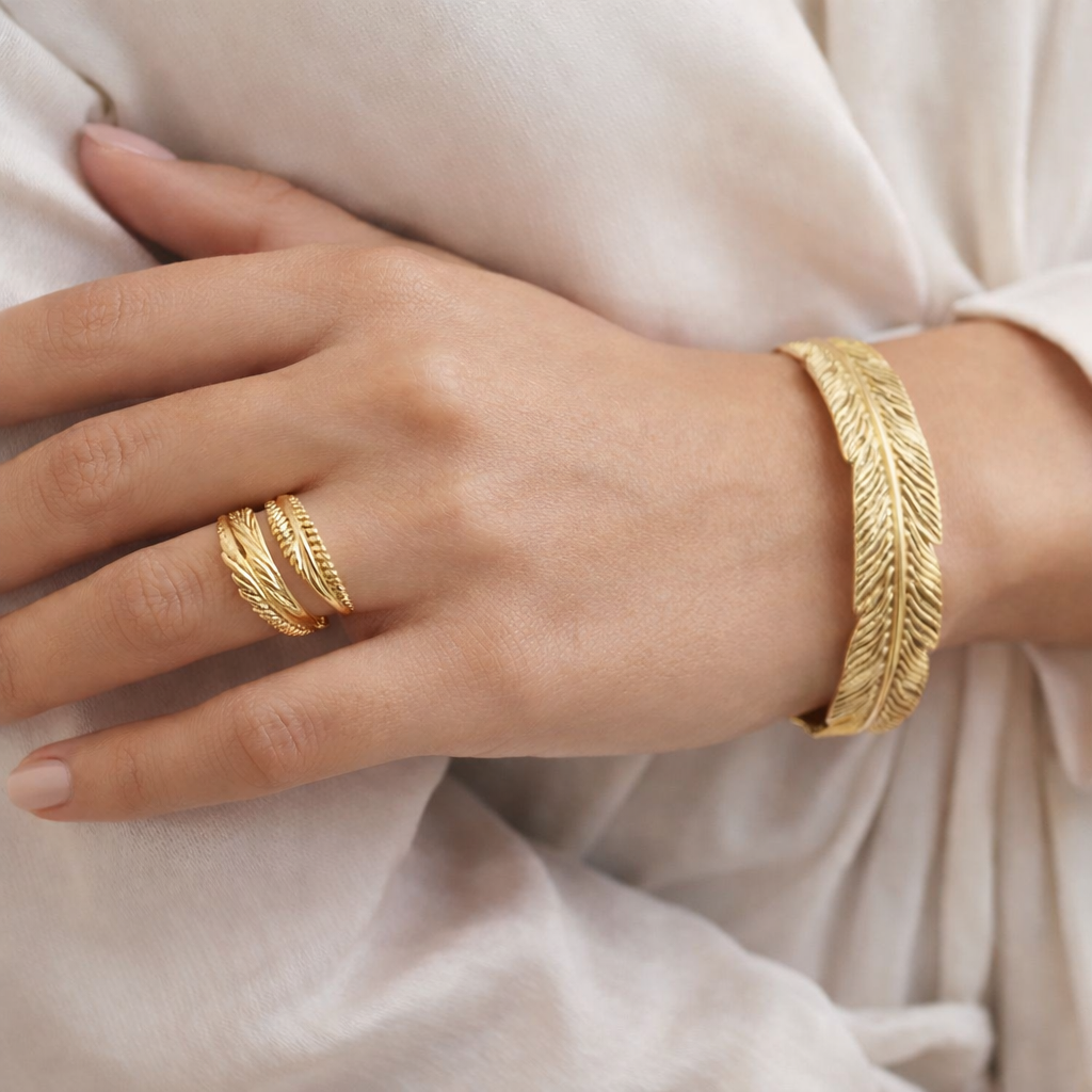 Jinam gold feather bracelet and ring set with nature-inspired design, featuring delicate feather motifs in elegant jewelry style.
