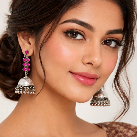 Oxidised silver Jhumka earrings with pink stone accents and intricate detailing, crafted by Jinam.