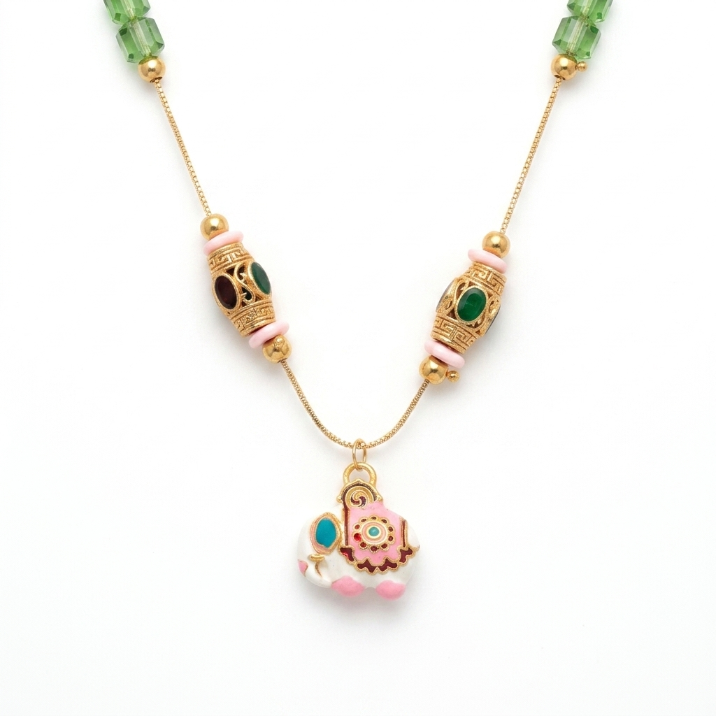 Close up of Meenakari Elephant Pendant and ornate gold Tibetan beads