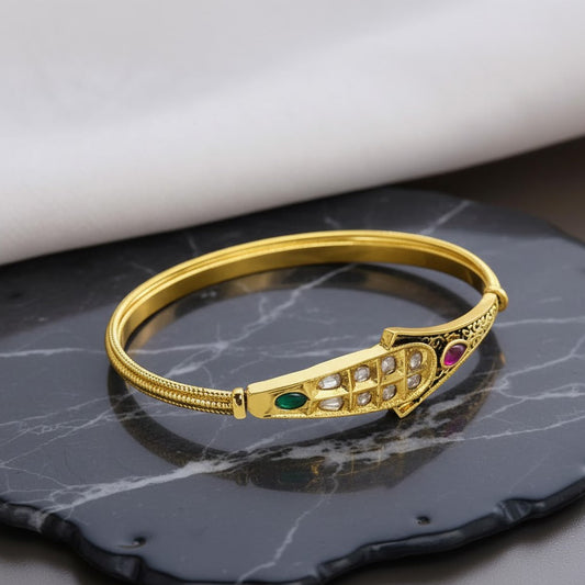 Gold Plated bracelet with gemstones on a dark marble surface